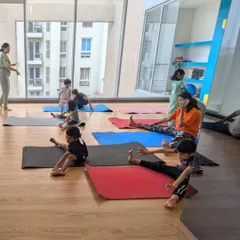 A wider view of our yoga and flexibility class, with students of different ages practicing together in a bright, open studio.