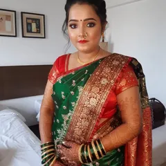 The 'after' reveal. A complete traditional Marathi bridal look, featuring a beautiful green and red saree, classic jewelry, and makeup that highlights her natural elegance.