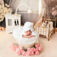 Can you believe she is just 10 days old? This little darling rocked every pose like a boss, especially in this adorable spa day setup with a tiny bathrobe and floral accents.