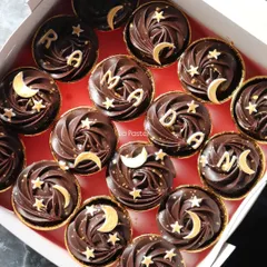 These "RAMADAN" cupcakes feature rich chocolate frosting and are decorated with edible gold moons and stars for a festive touch.