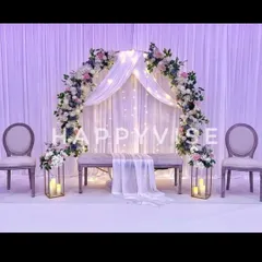 This dreamy engagement stage uses a floral arch over sheer, twinkling drapes to create a magical focal point. The soft lighting and elegant seating make it perfect for a romantic evening ceremony.