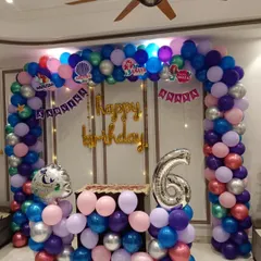 This Mermaid theme for a 6th birthday shows how I can adapt themes for different ages. The large balloon arch frames the party space, with a custom name banner and a number '6' foil balloon.