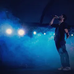 On stage, under the lights, sharing stories through music. This is my happy place. This shot captures the feeling of performing for a large audience, perfect for when your event needs that big concert vibe.