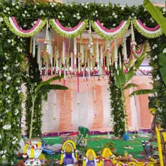 A close-up of a traditional mandap, showing the intricate floral work and items for the puja.