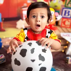 To infinity and beyond! This little Woody from Toy Story is just the cutest. His surprised expression is priceless, making this a truly memorable first birthday photo.