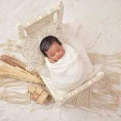 The peaceful, sleepy moments of a newborn are so fleeting. I specialize in creating serene and safe setups, like this cozy macrame bed, to capture your baby's earliest days in a simple, beautiful way.