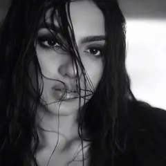 This close-up in monochrome emphasizes the raw emotion and the artistry of the makeup. The smudged liner and dewy skin texture are central to this moody, atmospheric shot.