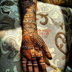 Here is a full-arm bridal design with rich, dark staining. The pattern includes architectural domes, floral bands, and classic jaali work on the fingers, creating a truly magnificent look.