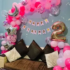 A slightly different angle of the pink-themed second birthday home decoration, showing the full balloon arch and "Happy Birthday" banner.