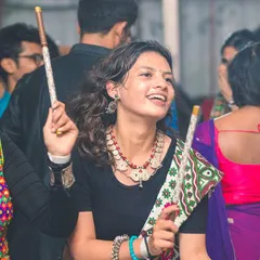A smiling dancer with her dandiya sticks, lost in the rhythm of the Garba music. The joy and cultural pride at these events are infectious.