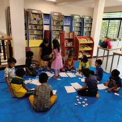 Working on a counting activity on the floor. These hands-on games help children visualize numbers and understand mathematical concepts in a tangible way.