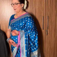 A side view of this beautiful mature skin makeup. The hair is styled in a classic bun with gajra, completing the traditional look.