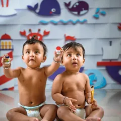 Two little artists showing off their work. This is another creative setup I designed specifically for a fun and interactive twin photoshoot.