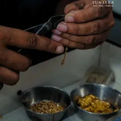 Crafting jewellery often involves working with hundreds of tiny components. This shot shows an artisan meticulously assembling a gold chain link by link, a process that demands patience and a keen eye for detail.