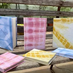 My collection of handmade notebooks, covered with fabric that I naturally dyed myself. They are available with ruled or unruled paper and are perfect for journaling, sketching, or gifting.