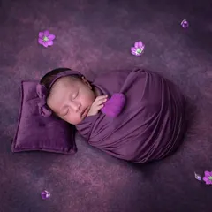 I'm in love with this beautiful purple setup. This sweet baby girl is swaddled comfortably, resting on a tiny matching pillow. Using a single colour scheme creates such a striking and artistic newborn photograph.