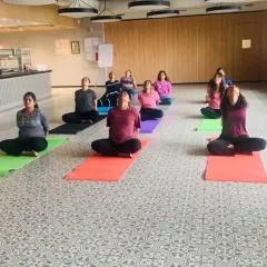 A group of employees opening their chests and hearts in a seated backbend during a Hatha yoga session at Johnson & Johnson.