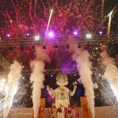 A spectacular shot of a grand wedding entrance with a large Ganesha idol, fireworks, and smoke effects, creating a truly divine atmosphere.
