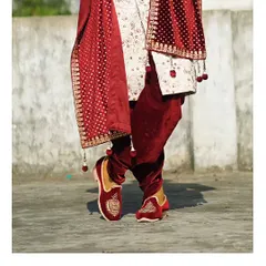 It's all in the details. This shot highlights the complete royal look, from the embroidered sherwani and velvet dupatta to the matching juttis.