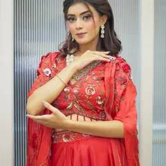 A beautiful Karva Chauth look featuring a modern red ensemble. The makeup is soft yet festive, with defined eyes and a hint of sindoor, perfectly blending tradition with contemporary style.
