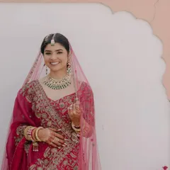 A full-length portrait of the bride in her hot pink lehenga. The makeup is designed to look flawless both up close and from a distance, ensuring she looks perfect in every photo.