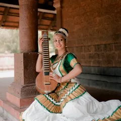 A portrait of a Mohiniyattam dancer with her instrument. The setting and her pose create a serene and artistic image that celebrates classical Indian culture.