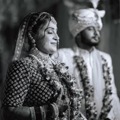 A serene black and white photo taken during the ceremony. The bride's peaceful expression as she soaks in the moment, with her groom in the background, creates a timeless and emotional image.