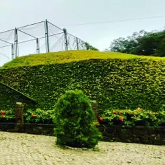 A detail of the stone-pitched earthen bund at the FINCH entrance. This technique, known as revetment, stabilizes the slope while creating pockets for landscaping, allowing the structure to become a living part of the hill.