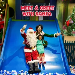 Guess who's sliding into the play area? Santa and his elf are here for a festive meet and greet! This photo captures a magical moment as they join a little guest on the slide.