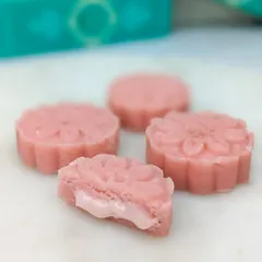 A close-up of our Rose Cake Mithai, cut open to show the creamy, fragrant filling inside its soft, pedha-like exterior.