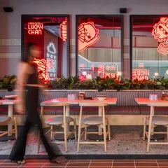 We used backlit mirrors featuring the 'Lucky' cat mascot to add a layer of brand storytelling. The red neon glow creates a dynamic and engaging visual element along the main seating bank.