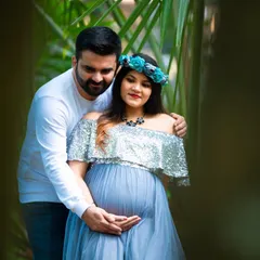 An intimate couple's portrait framed by nature. The lush green leaves create a natural frame, drawing focus to the couple's loving embrace.