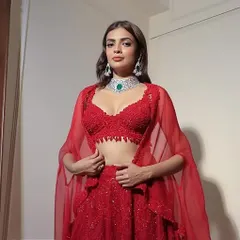 The perfect 2026 bride in a classic red lehenga. Her style is minimal, her presence unforgettable, paired with our signature diamond and emerald choker.