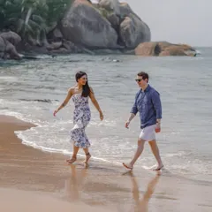 A relaxed and happy pre-wedding photo of a couple walking along the shores of a Goa beach.