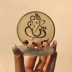 This mini Ganesha stand features a clear base with delicate dried flower petals embedded in the resin. It's a beautiful and serene design, perfect as a small token of appreciation.