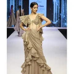 The full runway look of the draped saree gown. The combination of the structured, embellished corset and the soft, flowing ruffles creates a beautiful play on textures and forms.