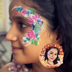 This design combines soft pink and blue flowers with a gentle turquoise butterfly. It's a perfect example of a whimsical floral face painting for any celebration.