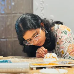 A participant carefully applies the golden lacquer to a repaired bowl. This close-up shows the delicate, mindful process of Kintsugi, where every crack is highlighted as a part of the object's history.