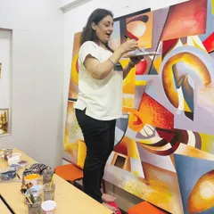 The joy of creation is an essential ingredient in my work. This candid shot captures a moment of happiness as I mix colors and apply them to the canvas, pouring positive energy into the abstract masterpiece.