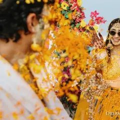 A playful moment between the couple during their beachside Haldi. The vibrant yellow outfits and cheerful atmosphere perfectly capture the spirit of this fun-filled tradition.