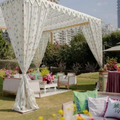 A closer look at one of the seating areas, with a custom-printed fabric canopy, comfortable sofas adorned with themed cushions, and colorful floral arrangements. This shows how we create distinct zones within a large outdoor space.