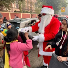 The true spirit of Christmas. A member dressed as Santa gives a warm blanket to a child on the street. These moments are the reason we organize our annual charity ride.