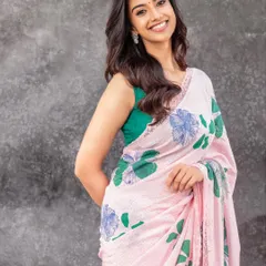 Another shot from the floral saree series, showing a slightly different pose. The styling is consistent, focusing on a happy, approachable aesthetic for contemporary Indian fashion.