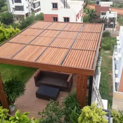 A high-angle view of a completed pergola project. We integrated a wooden-finish roof and side panels with a durable WPC deck and comfortable seating to create a cozy, shaded outdoor lounge area.