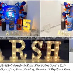 A supercharged Hot Wheels theme for a fifth birthday at home. The setup features a dynamic backdrop, themed cylinder tables, and a light-up number "5", bringing the excitement of the race track indoors.