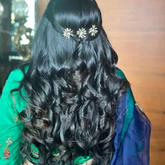 A beautiful hairstyle for this mom-to-be. The soft curls and delicate floral hair accessory create a look that is elegant and graceful.