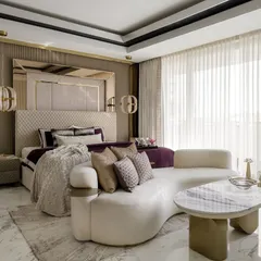 Comfort takes center stage in this luxurious master bedroom. We introduced a bold plum color in the bedding, a dramatic upholstered headboard with mirrored panels, and a plush, curved seating nook to make the room feel like a destination.