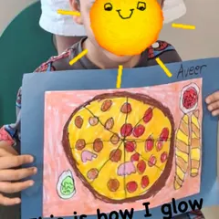 This student is glowing with pride after creating a delicious-looking pizza artwork. Our classes help children feel successful and capable, which shines through in their happy faces.