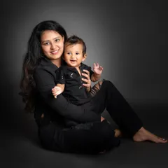 A beautiful mother and son portrait. Matching in black, their smiles shine, creating a simple yet powerful image of their connection.