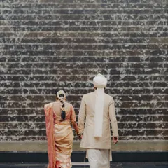 Walking together towards their future. This shot, taken from behind against a textured waterfall, symbolizes their journey as a couple in their beautiful wedding attire.